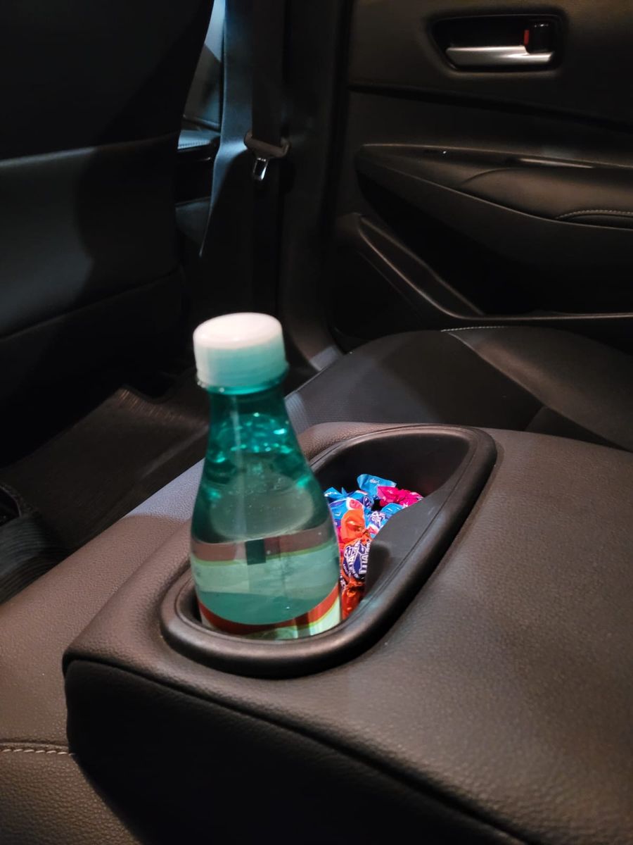 Água e docinhos no porta-copos do carro